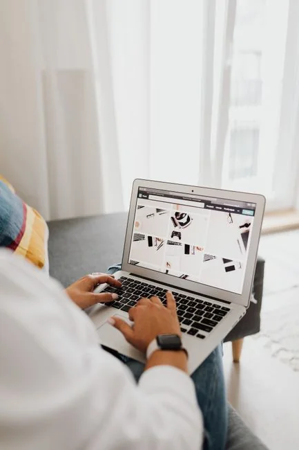 Person analyzes stock data with a smartphone and laptop, indoors.